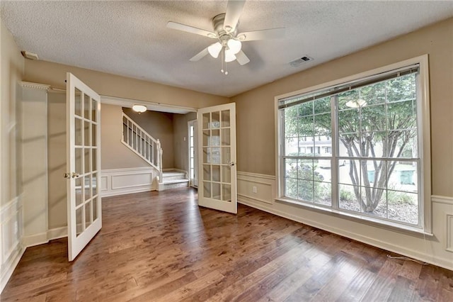 12060 Carriage Park Ln, Duluth, GA 30097 - unfurnished room featuring french doors, a textured ceiling, wood finished floors, ceiling fan, and a decorative wall