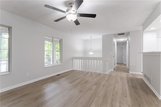 740 Stoneside Ct, Stone Mountain, GA 30083 - empty room with light wood-type flooring, a ceiling fan, baseboards, and a textured ceiling