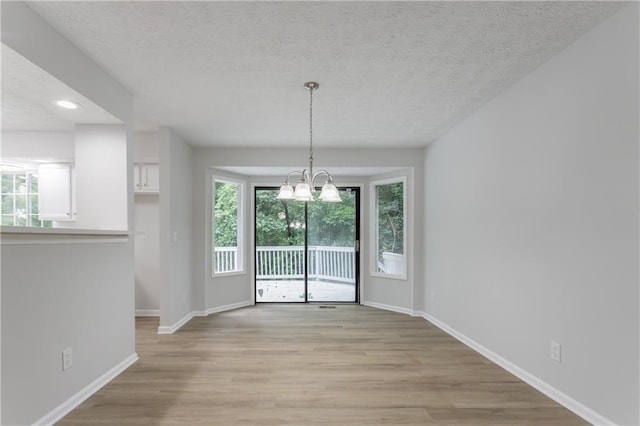740 Stoneside Ct, Stone Mountain, GA 30083 - unfurnished dining area featuring baseboards, light wood-type flooring, a chandelier, a textured ceiling, and recessed lighting
