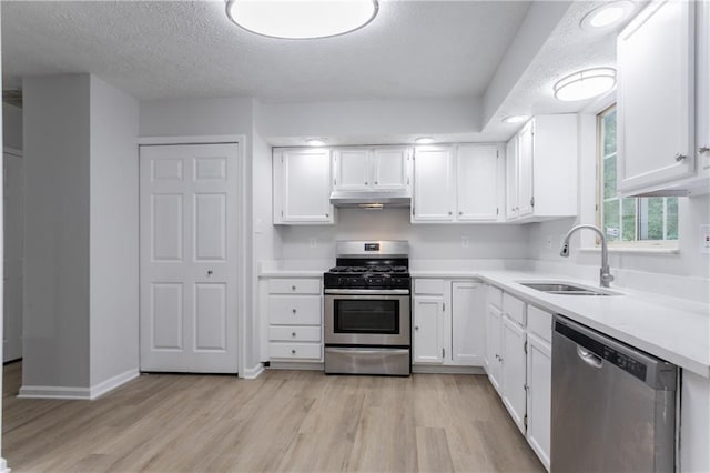 740 Stoneside Ct, Stone Mountain, GA 30083 - kitchen with appliances with stainless steel finishes, a sink, light wood-type flooring, a textured ceiling, and white cabinets