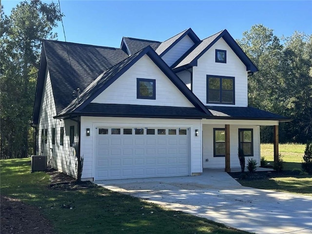 view of front of house featuring a garage, a front yard, and central AC unit