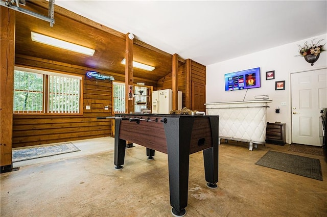 rec room featuring concrete floors and wooden walls