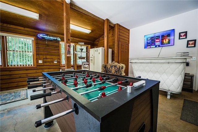 game room featuring lofted ceiling and wooden walls