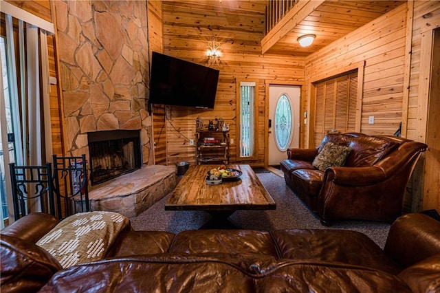 living room featuring carpet floors, wooden walls, wooden ceiling, and a fireplace