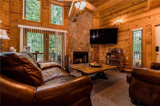 carpeted living room featuring high vaulted ceiling, wooden ceiling, wooden walls, ceiling fan, and a fireplace