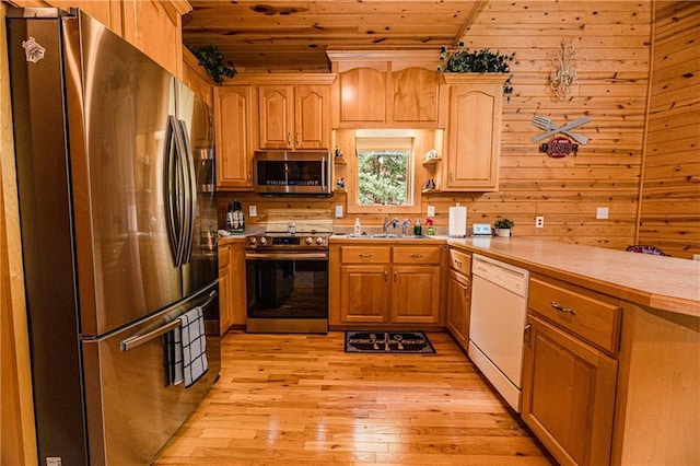 kitchen with appliances with stainless steel finishes, wooden walls, sink, wood ceiling, and light hardwood / wood-style flooring