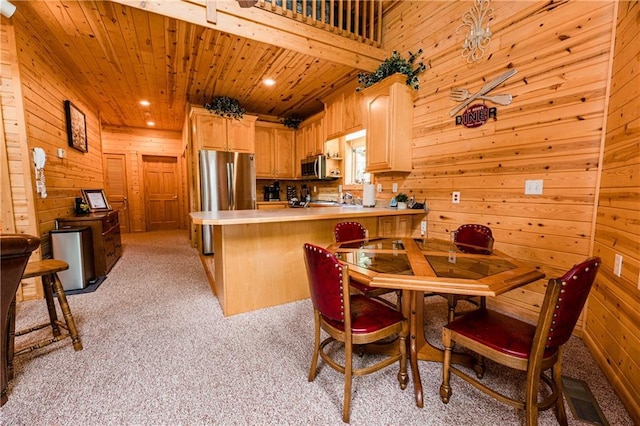 kitchen featuring stainless steel appliances, light carpet, wooden ceiling, kitchen peninsula, and light brown cabinets