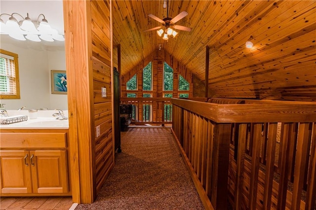 corridor with lofted ceiling, sink, wood ceiling, and carpet flooring