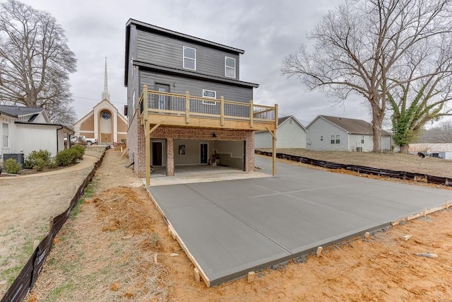 back of house featuring a wooden deck and a patio