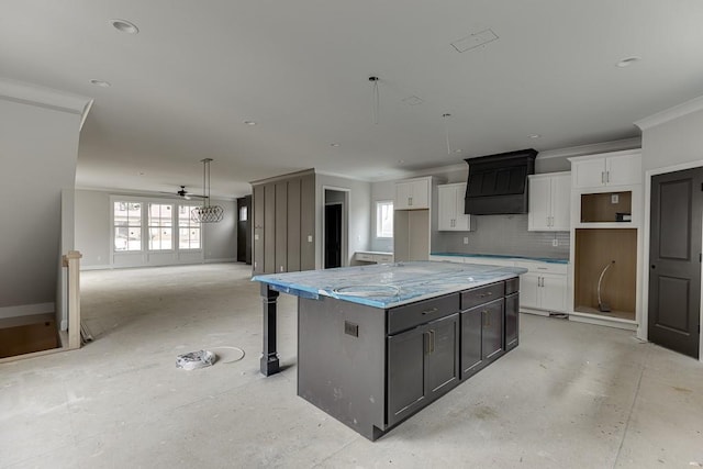 kitchen featuring tasteful backsplash, a large island, white cabinets, and light stone counters