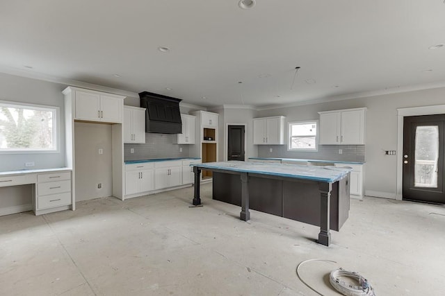 kitchen featuring a kitchen island, a breakfast bar area, white cabinets, and decorative backsplash