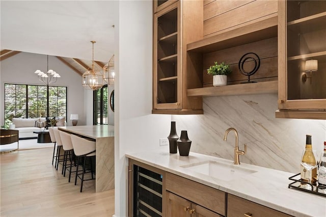3292 Lenox Pl NE, Atlanta, GA 30324 - indoor bar with beverage cooler, light wood-type flooring, decorative backsplash, lofted ceiling, and hanging light fixtures