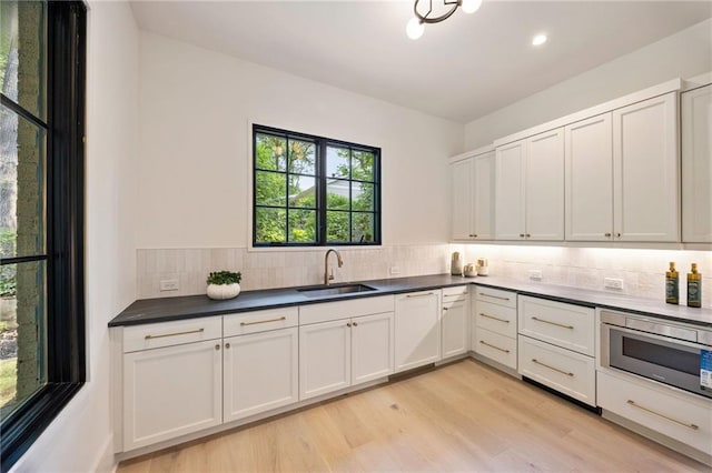 3292 Lenox Pl NE, Atlanta, GA 30324 - kitchen featuring tasteful backsplash, light wood-style flooring, dark countertops, recessed lighting, and stainless steel microwave