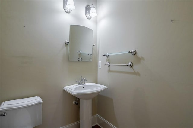 bathroom with toilet and baseboards