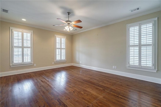 unfurnished room with dark wood-style floors, visible vents, and crown molding