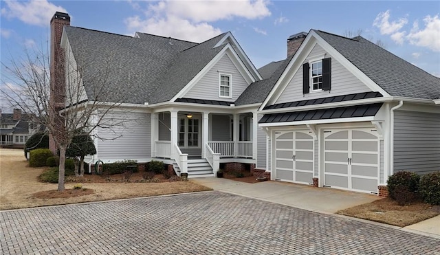 view of front of home featuring decorative driveway, a standing seam roof, and a chimney