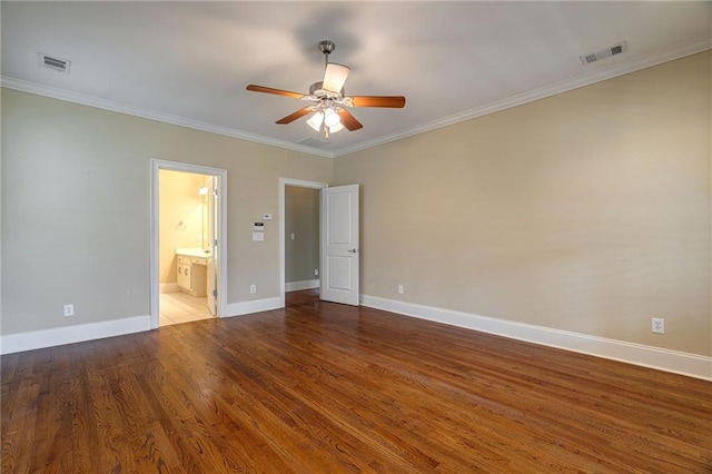 unfurnished bedroom featuring baseboards, ornamental molding, visible vents, and wood finished floors