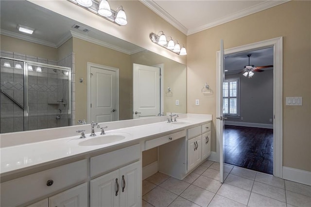 full bath featuring double vanity, a sink, tile patterned floors, crown molding, and a shower stall