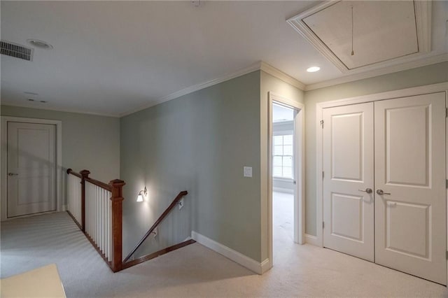 hall featuring an upstairs landing, attic access, visible vents, baseboards, and light carpet