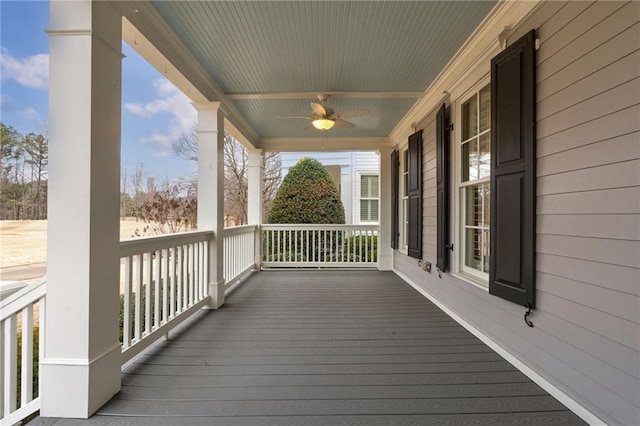 wooden terrace with covered porch and a ceiling fan