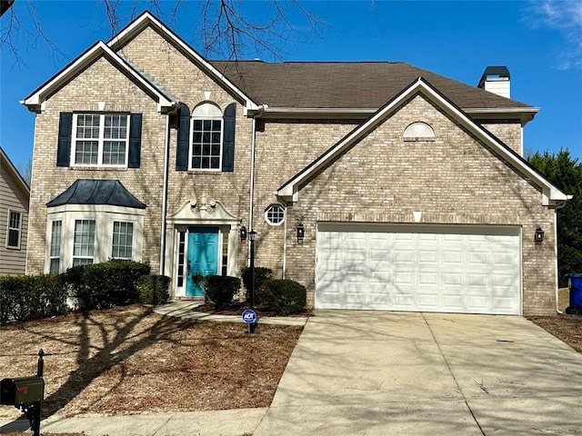 view of front of property with a garage, brick siding, driveway, and a chimney