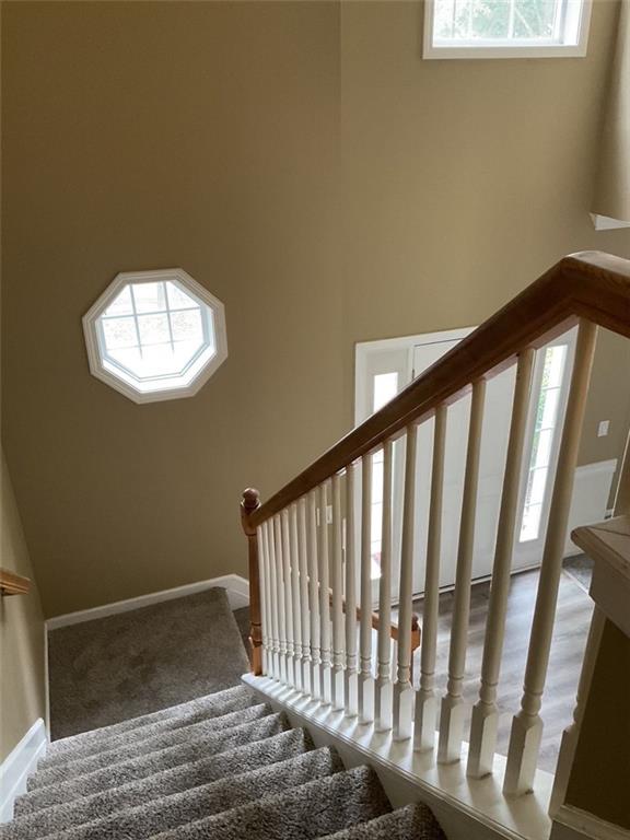 stairway with a wealth of natural light and baseboards