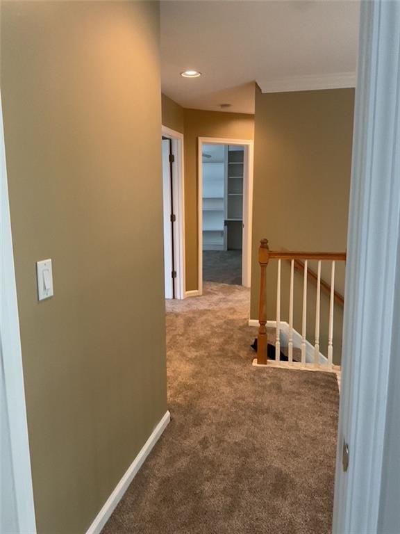 corridor with carpet, recessed lighting, ornamental molding, an upstairs landing, and baseboards