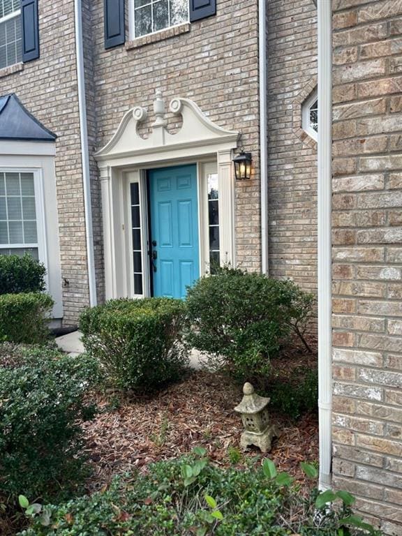 doorway to property featuring brick siding