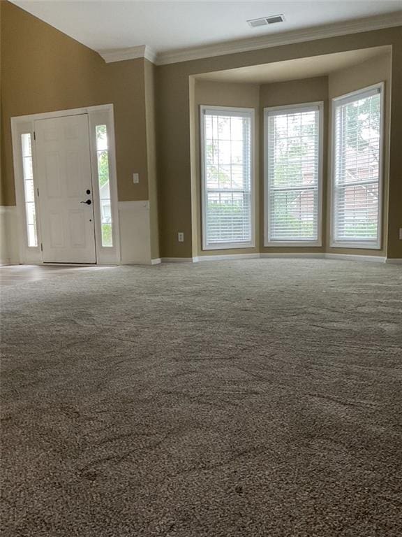 interior space featuring visible vents, crown molding, and carpet flooring