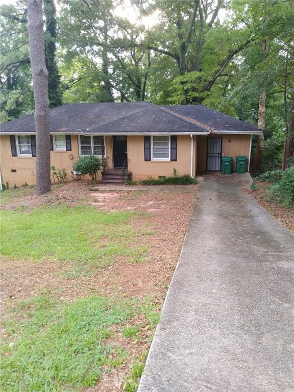 ranch-style home with a shingled roof and aphalt driveway