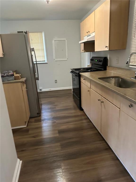 kitchen featuring black electric range oven, baseboards, dark wood-type flooring, under cabinet range hood, and a sink