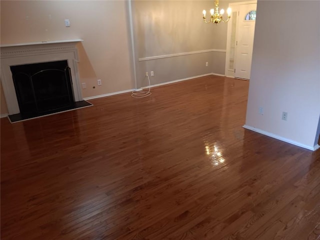 unfurnished living room featuring dark hardwood / wood-style flooring and an inviting chandelier