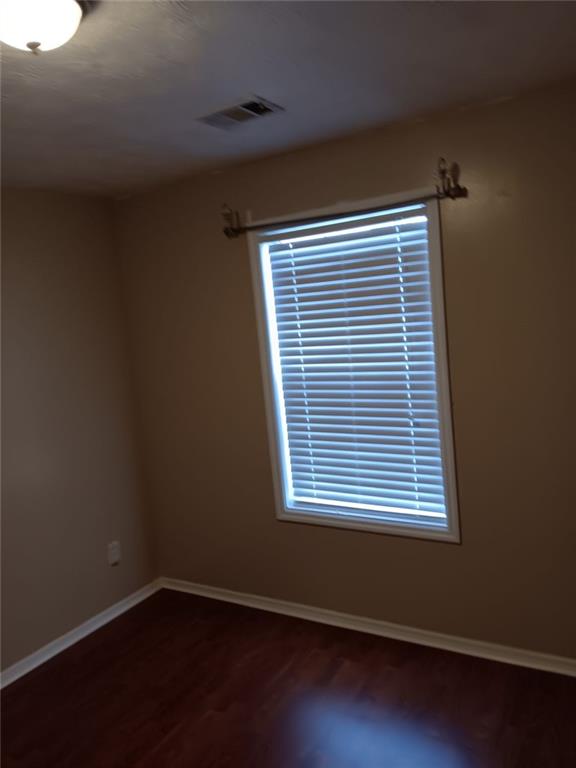 spare room with dark wood-type flooring