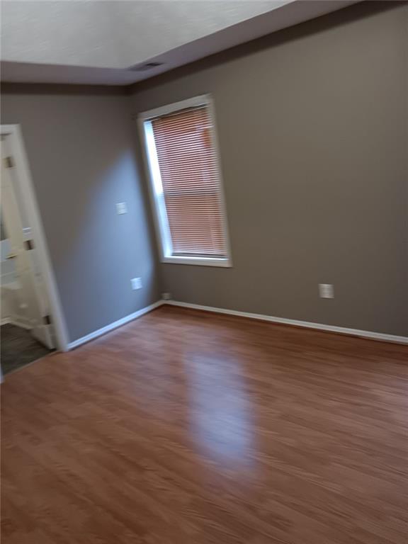 unfurnished room with dark wood-type flooring