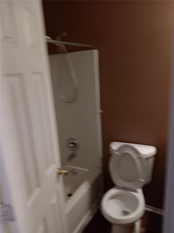 bathroom featuring toilet and bathing tub / shower combination