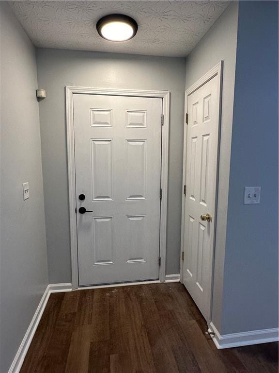 doorway featuring dark hardwood / wood-style floors and a textured ceiling