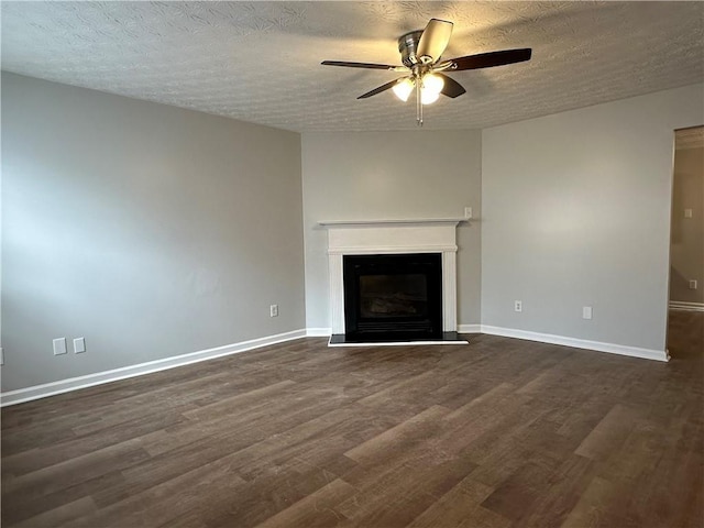 unfurnished living room featuring ceiling fan, dark hardwood / wood-style floors, and a textured ceiling