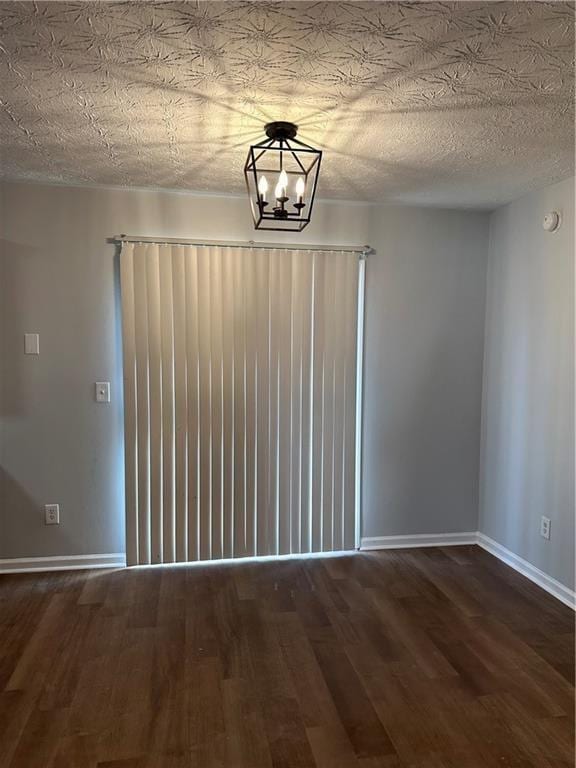 unfurnished dining area with dark hardwood / wood-style flooring, a textured ceiling, and a notable chandelier