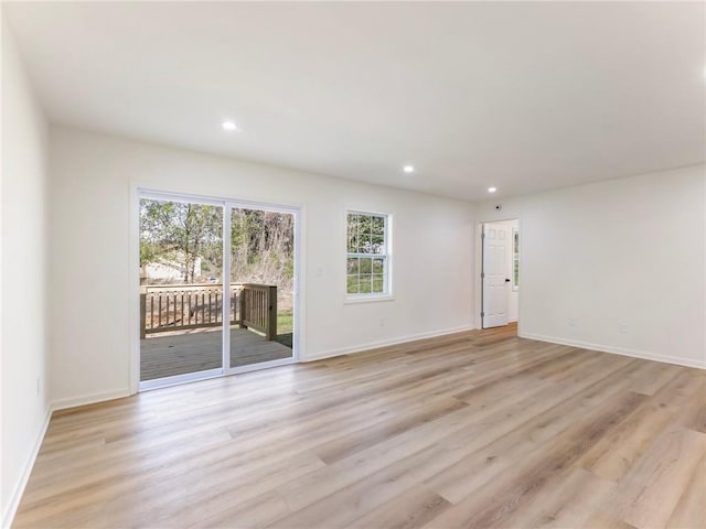 empty room featuring light wood-type flooring, plenty of natural light, and recessed lighting