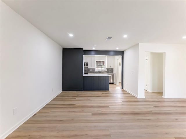 unfurnished living room featuring recessed lighting, visible vents, and light wood-type flooring