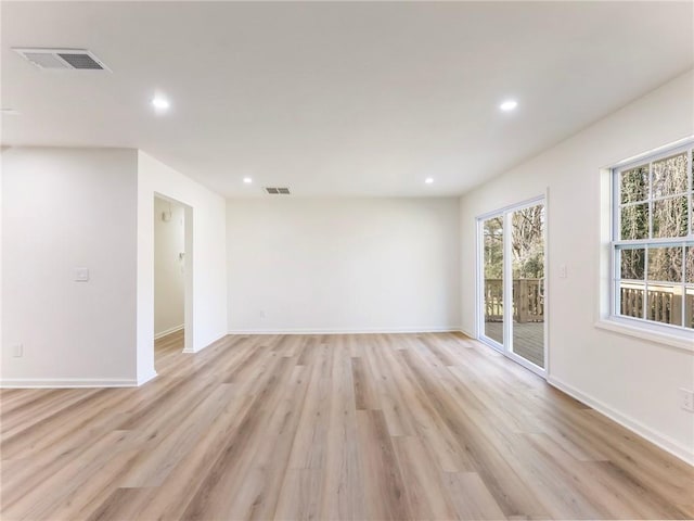 empty room featuring recessed lighting, light wood-style flooring, and visible vents