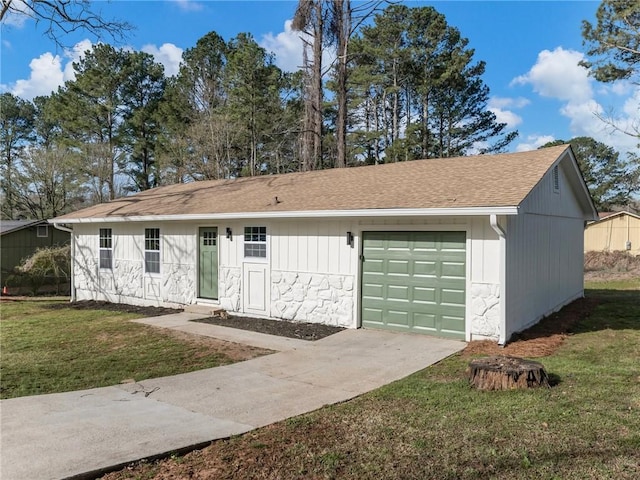 ranch-style home featuring a garage, a shingled roof, a front yard, and concrete driveway