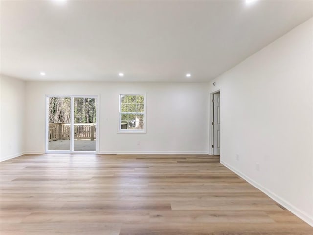 empty room with light wood-style flooring, baseboards, and recessed lighting