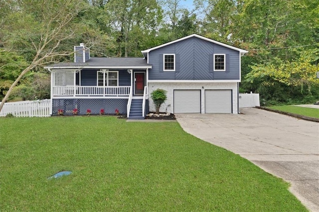 split level home featuring covered porch, a garage, and a front lawn