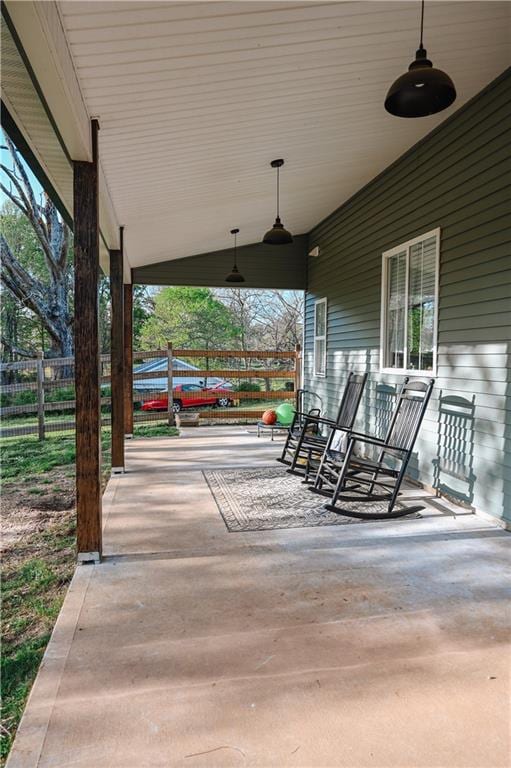 view of patio / terrace with a ceiling fan, a porch, and fence