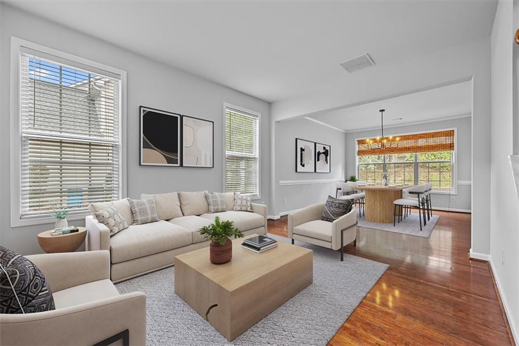 living room featuring wood-type flooring and an inviting chandelier