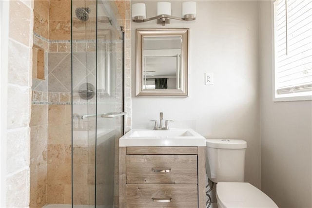 bathroom featuring toilet, a stall shower, and vanity