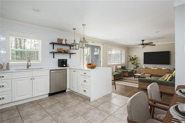 kitchen with dishwasher, crown molding, a wealth of natural light, and a sink