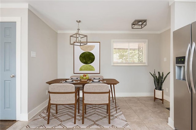 dining space with light tile patterned floors, crown molding, and baseboards