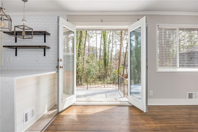 entryway with wood finished floors, visible vents, and baseboards